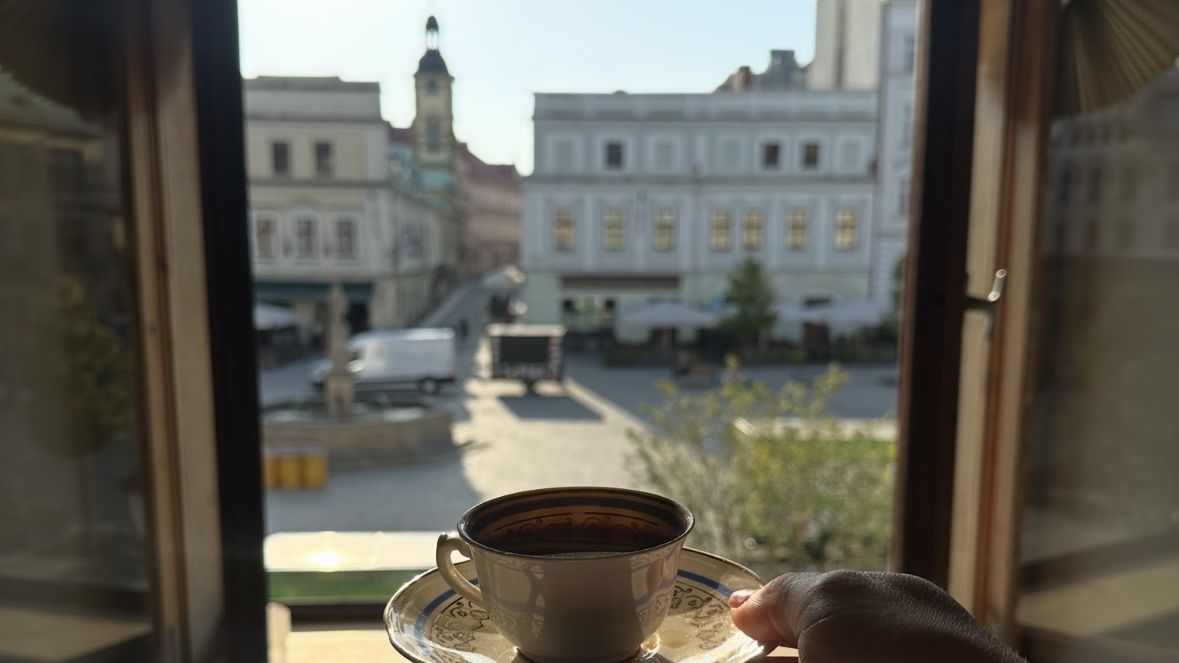 Filiżanka kawy w otwartym oknie z widokiem na cieszyński Rynek